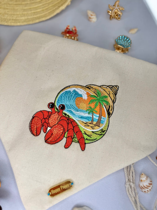 Detalle de la bandana para perro Paradise de Happy Puppy Bandanas en crema con caracola tropical y cangrejo ermitano bordados a color