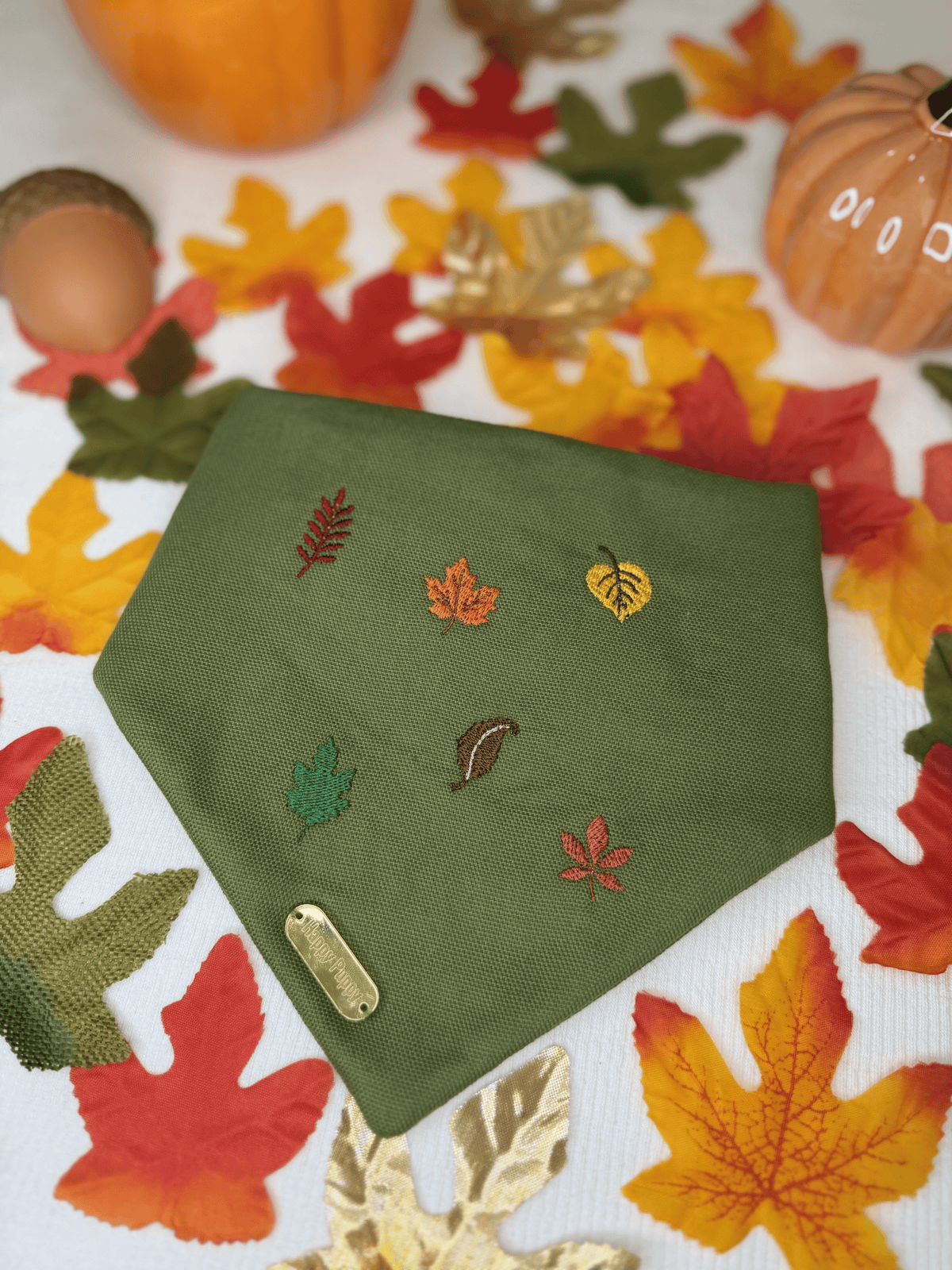 Bandana para perro Autumn Leaves de Happy Puppy Bandanas en verde oliva con hojas de otono bordadas en tonos rojo, mostaza y verde, vista frontal