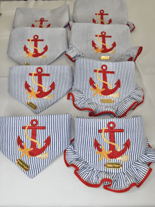 Bandana para perro Beach Anchor de Happy Puppy Bandanas, tela de rayas azul marino y blanco con ancla y estrella de mar bordadas en rojo, vista de grupo con modelos de volante rojo