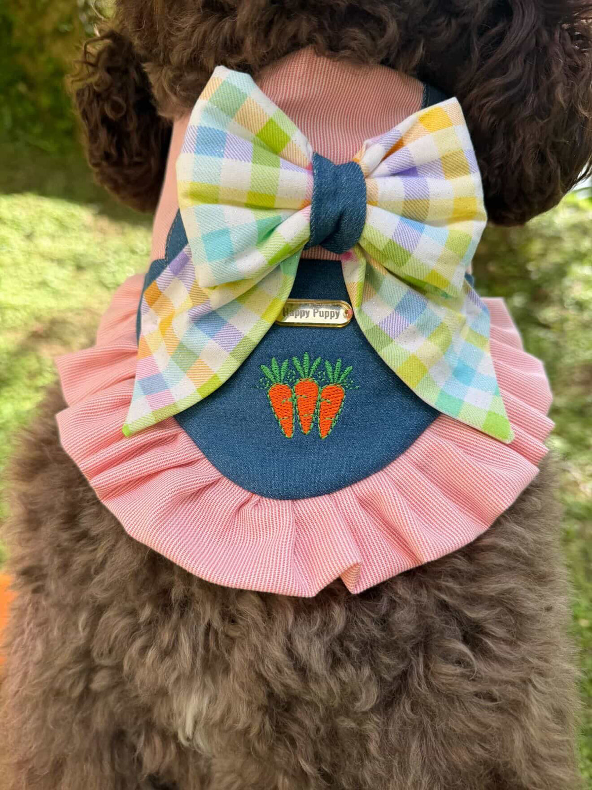 Detalle de un perro usando la bandana Bunny Jumper Girl de Happy Puppy Bandanas en rosa y mezclilla con zanahorias bordadas y lazo de cuadros pastel