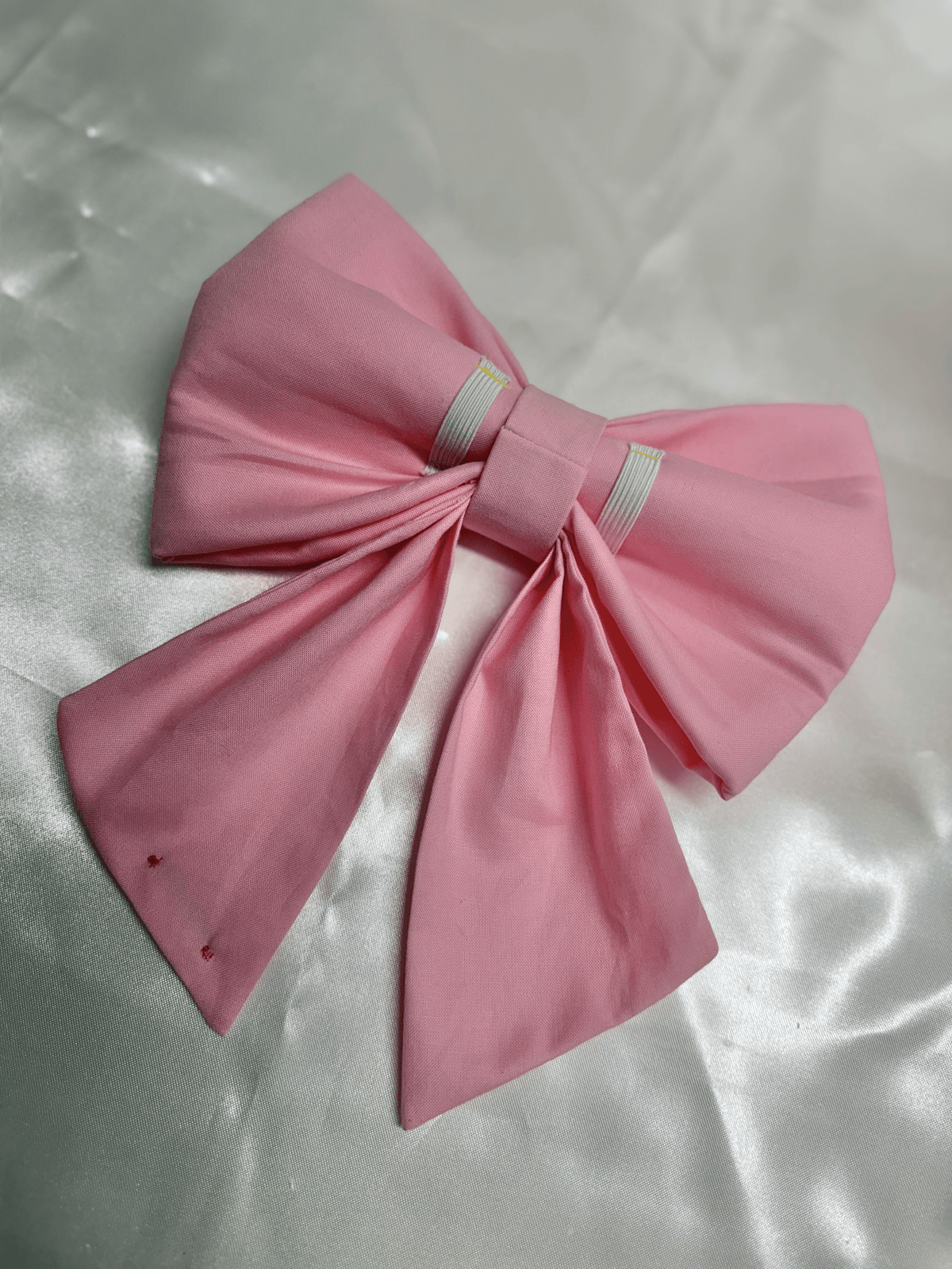 Sailor bow para collar de perro Light Pink Sailor Bow de Happy Puppy Bandanas en rosa claro, vista frontal sobre fondo de satin blanco