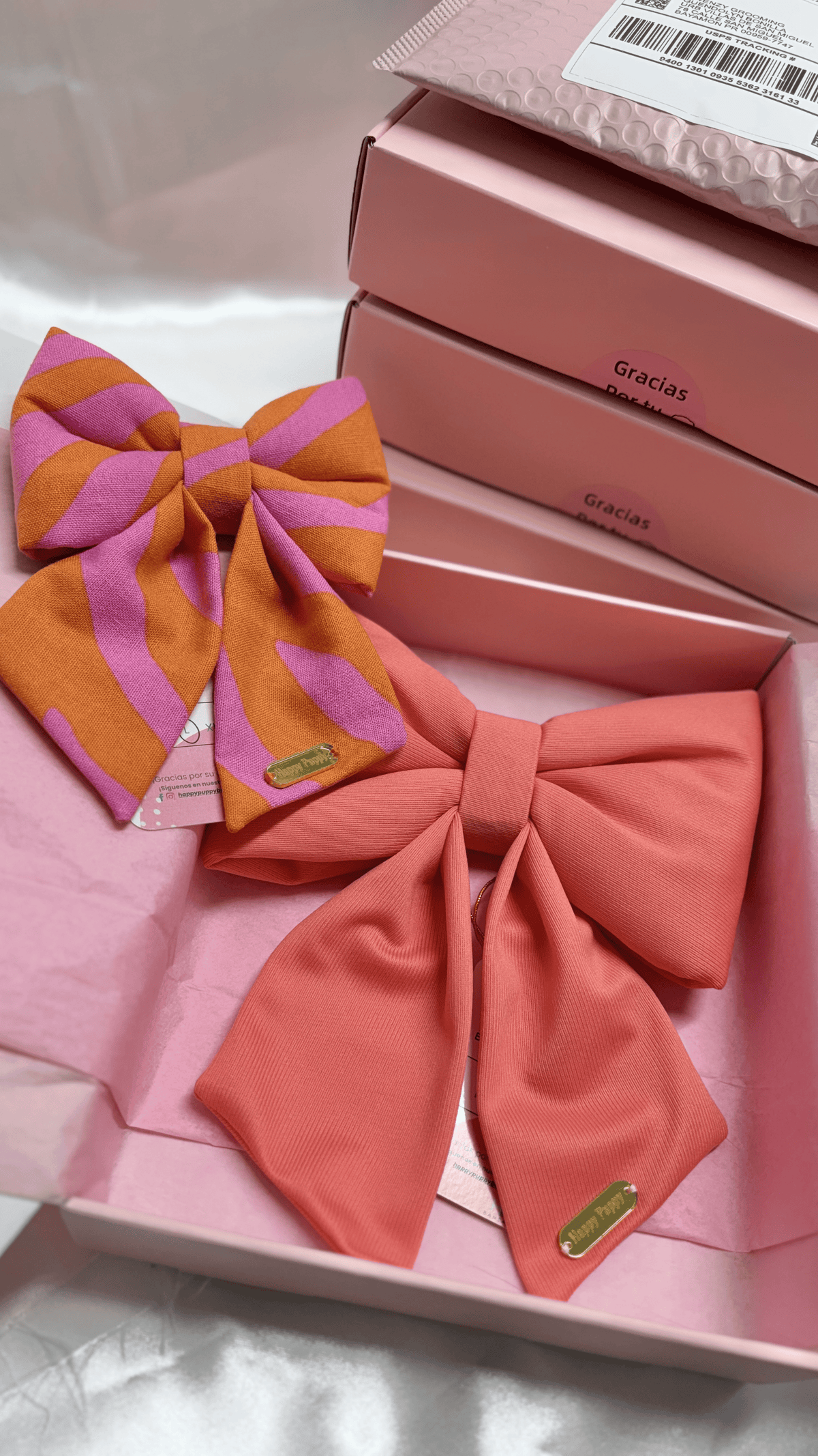 Detalle de sailor bows para collar de perro Pink Sailor Bows de Happy Puppy Bandanas en rayas rosa y naranja junto a uno en coral liso