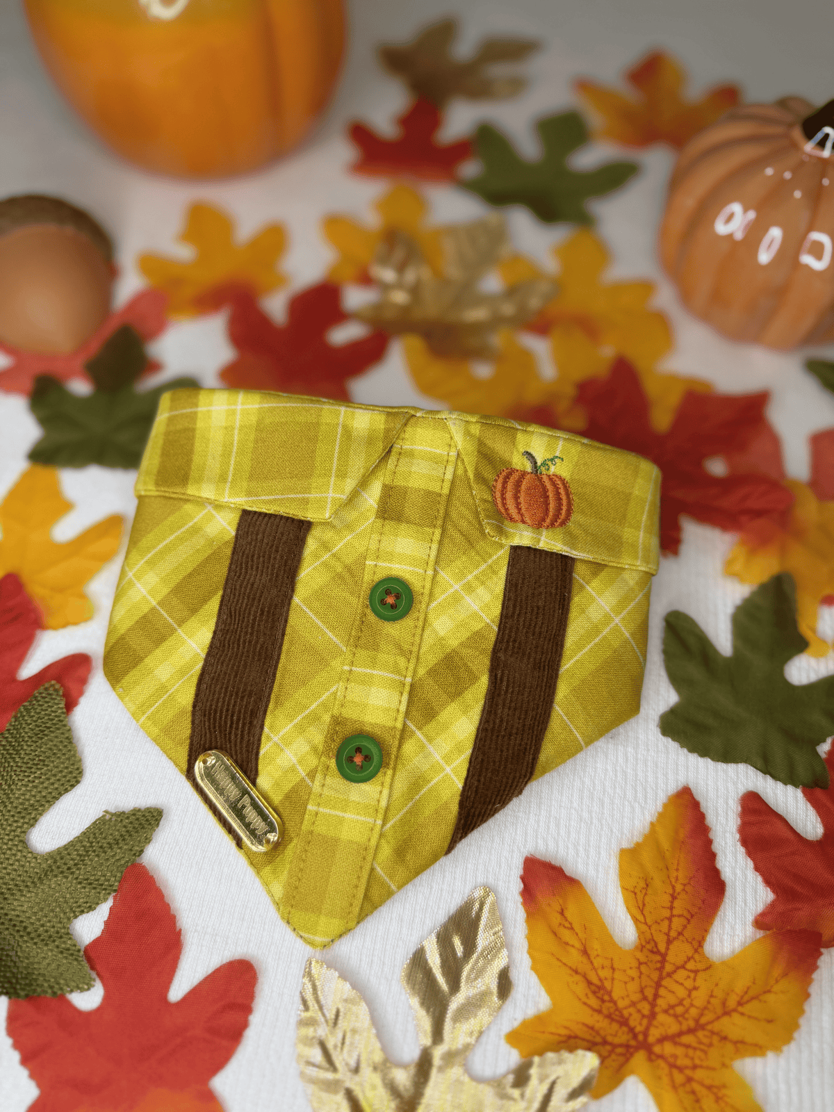 Bandana para perro Pumpkin Spice de Happy Puppy Bandanas en cuadros amarillo mostaza con tirantes marrones, botones y calabaza bordada, vista frontal