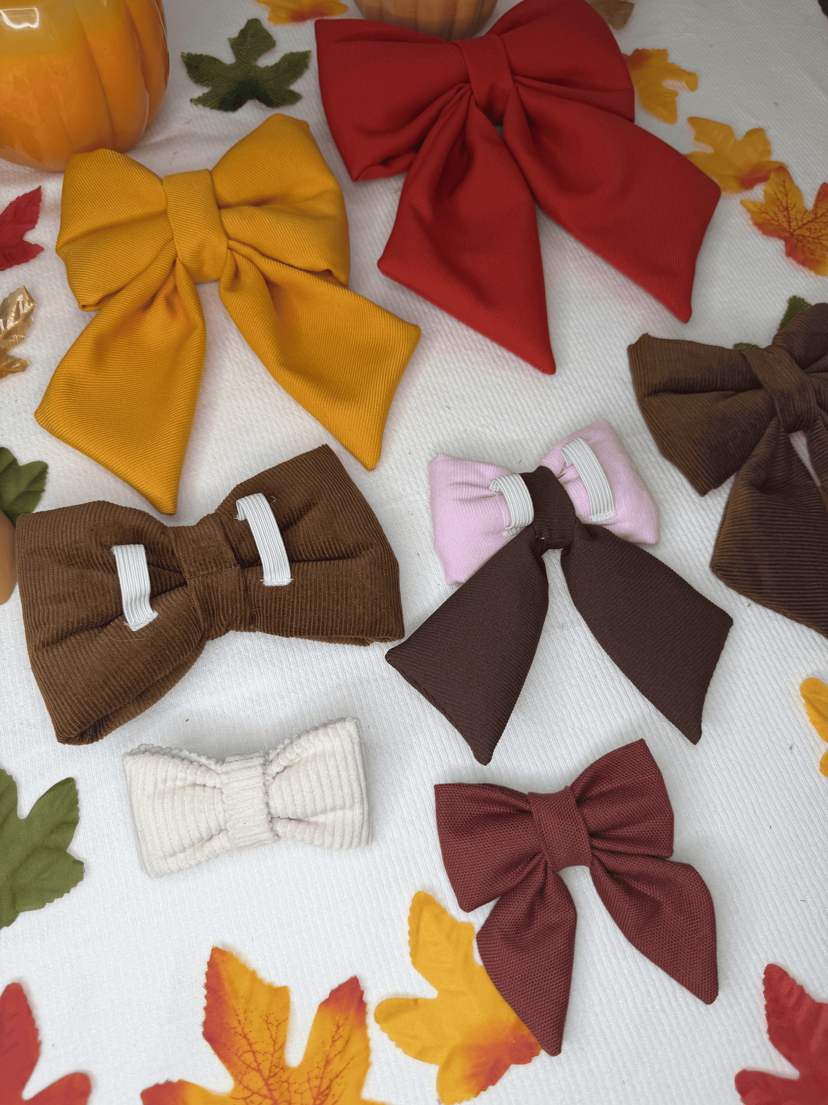 Sailor bows y bow ties para collar de perro de Happy Puppy Bandanas en tonos de otono mostaza, vino, marron y rosa, vista de grupo sobre hojas de otono