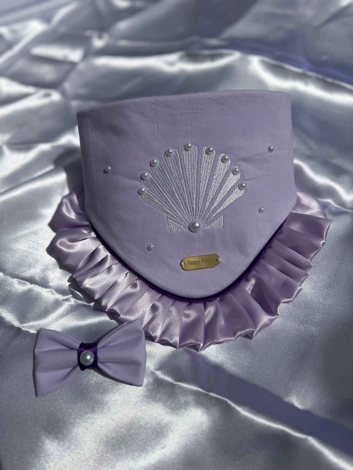 Bandana para perro Sea Shell de Happy Puppy Bandanas en lila con concha bordada en hilo plateado, volante de satin y bow tie a juego, vista frontal